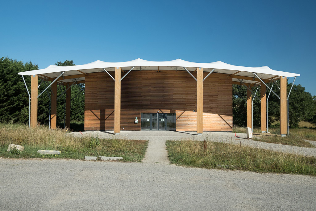 Salle multisport de 900m² réalisée en ossatures bois, toile tendue, bardage acier et bois