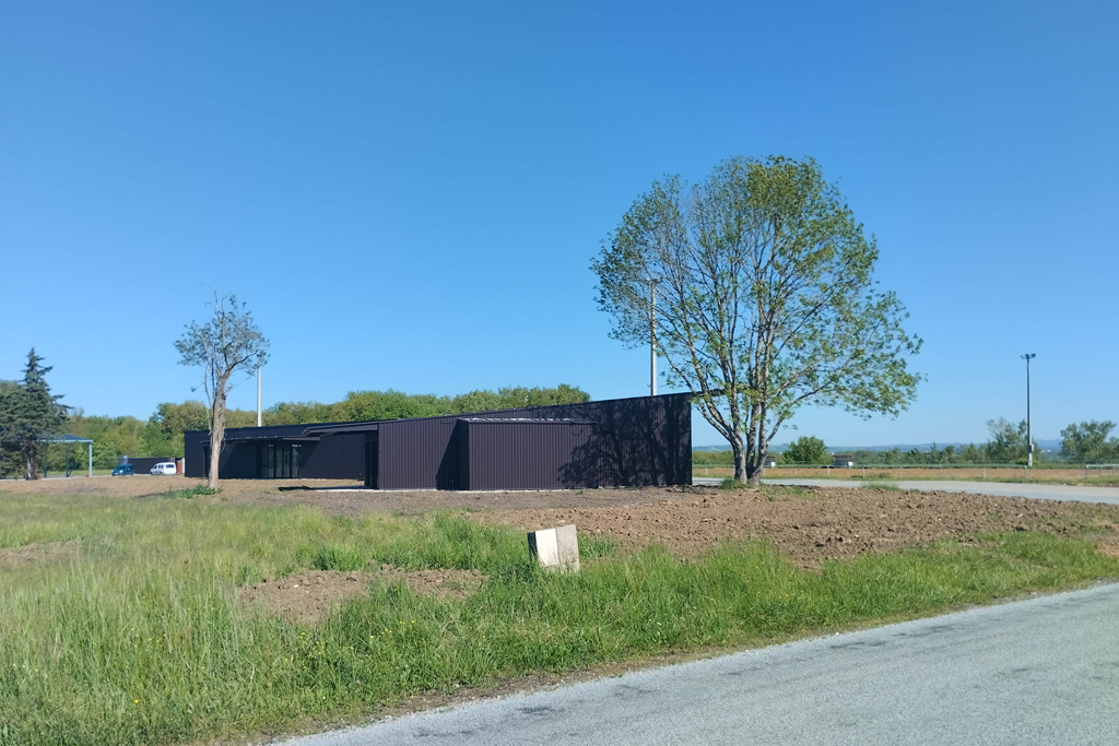 Rénovation et extension de 2 bâtiments existants en salles de réunion et Club House. Les 2 ensembles sont entièrement habillés en bac acier ton brun foncé afin d'assurer la cohérence de l'ensemble
