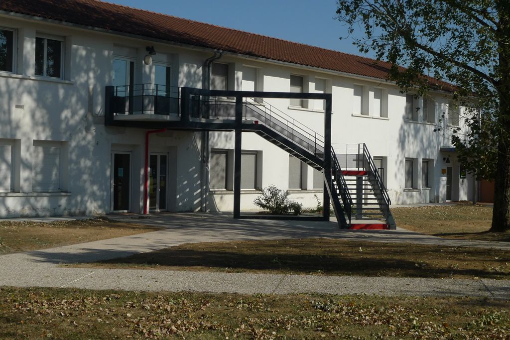 Escalier métallique pour accéder à l’étage du bâtiment de la Communauté de Communes Val 81, ne créant pas d'ombre sur les bureaux du RDC, mettant en valeur le bâtiment et permettant la mise en place d'une signalétique dans un cadre prévu à cet effet